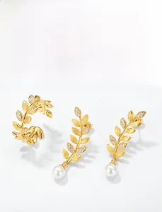 Detail of brushed gold leaf earrings with zircon pavé and large round white pearls