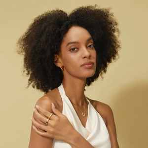 Close-up of gold S925 silver jewelry set with rings, necklace and textured earrings