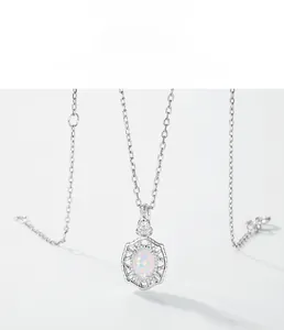 Macro detail of oval opal pendant necklace featuring vintage hollow engraving and zircons