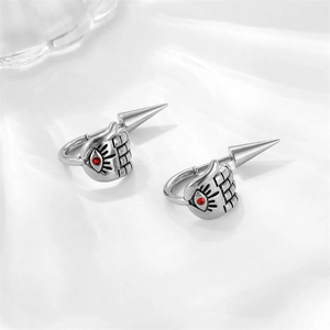 Detail of gothic hand grasping cone earring with red zircon and evil eye motif