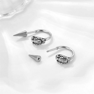 Detail of vintage silver dragon head stud earrings featuring screw-on cone back closures