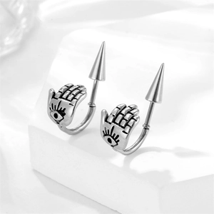 Macro shot of punk style stainless steel ear cuff with palm and spike on white stone base