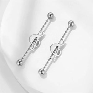 Detailed close-up of music note industrial barbell earrings in polished silver steel