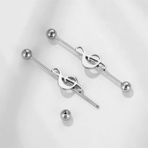 Macro view of musical note industrial barbells in polished stainless steel for ear piercings