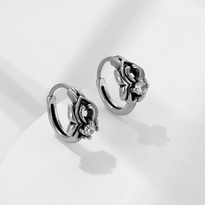 Boucles d'oreilles vintage en argent ajouré avec zircon sur fond blanc minimaliste