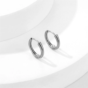 Sleek silver stainless steel hoop earrings with vertical grooved texture on a white stand