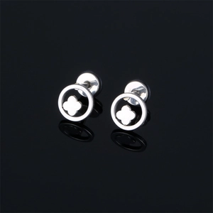 Minimalist stainless steel clover stud earrings on a reflective black surface