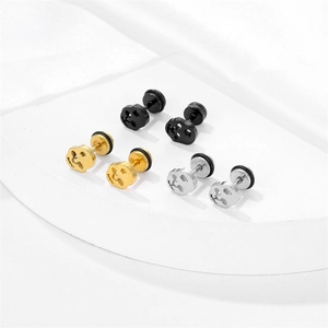 Gothic skull stud earrings set in black gold and silver tones on white display stand