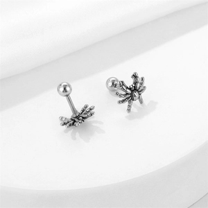 Gothic spider stud earrings in vintage stainless steel on a white luxury silk background