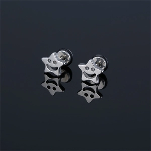 Boucles d'oreilles étoiles en acier inoxydable avec sourire et reflet sur fond noir