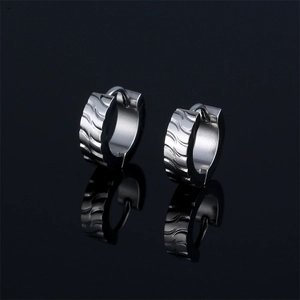 Boucles d'oreilles créoles en acier argenté poli avec motif ondulé sur fond noir