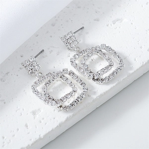 Close-up of sparkling square-shaped double-ring earrings with inlaid rhinestones