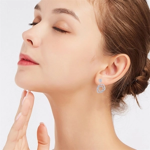 Close-up of geometric square double loop earrings with full pavé crystals on model