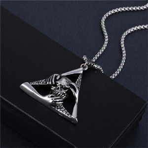 Close-up of retro silver skull pendant in geometric triangle with Gothic punk details