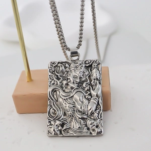 Macro detail of stainless steel pendant featuring engraved Buddhist mythology relief