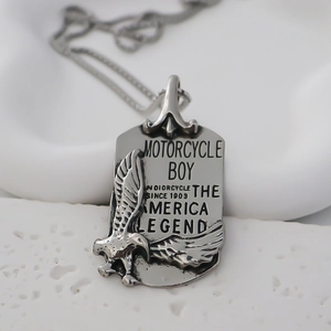 Macro detail of silver vintage eagle pendant with Motorcycle Boy engraved lettering