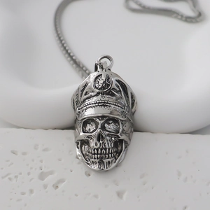 Gros plan du pendentif crâne argenté avec casquette militaire sur pierre blanche
