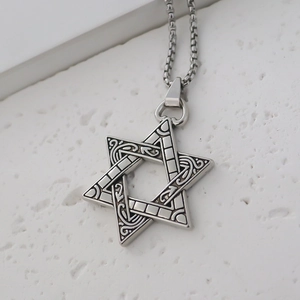 Macro shot of vintage star of david pendant with intricate filigree texture on box chain