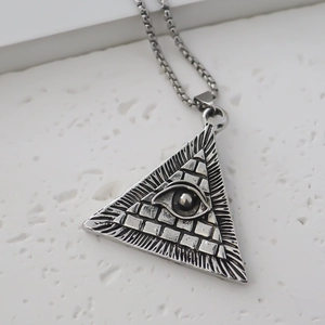 Macro view of vintage silver triangle Evil Eye pendant on a square box chain link