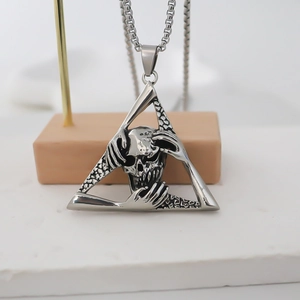 Macro shot of stainless steel gothic skull necklace with triangle pendant on a display