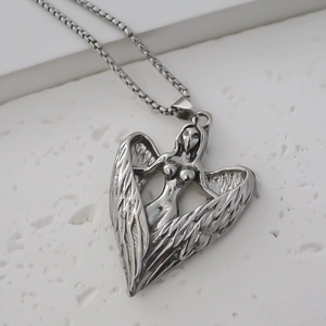 Macro shot of stainless steel angel wings necklace with heart shaped pendant detail
