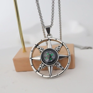 Détail macro du pendentif boussole nautique en acier inoxydable argenté sur un support