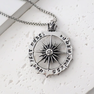 Close-up of vintage silver compass pendant with blackened finish on a square box chain