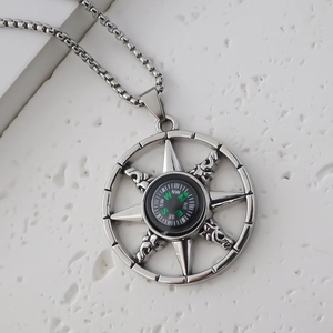 Gros plan détaillé du pendentif boussole en argent avec aiguille verte fonctionnelle