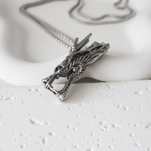Macro shot of retro metal dragon pendant necklace with detailed scales and o-chain