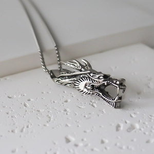 Macro shot of retro dragon head pendant with detailed carvings and antique silver finish