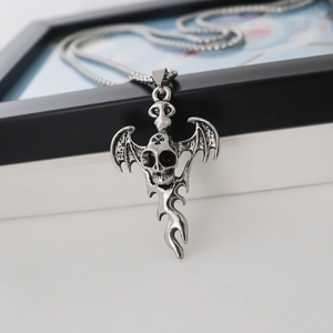 Gothic skull necklace with bat wings and flame detail on a metallic box chain