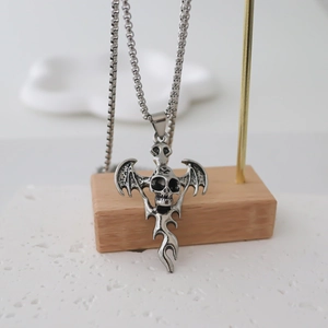Gothic bat skull pendant necklace detail hanging on a metallic display stand