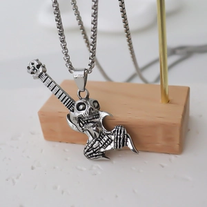 Vue macro du pendentif guitare crâne punk vintage avec finition argentée et chaîne box