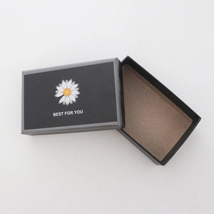 Détail de la boîte cadeau noire à marguerites avec texte Best For You et couvercle ouvert