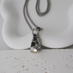 Macro detail of silver boxing glove pendant with realistic texture and link chain