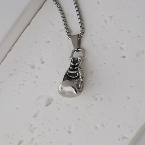 Detailed macro view of silver boxing glove pendant with textured laces and ball chain