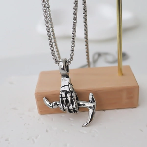 Gothic punk silver necklace featuring a detailed skull hand clutching a scythe pendant
