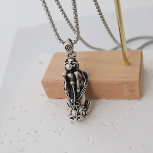 Detailed macro of vintage silver mythical monkey pendant with antique black oxidation finish
