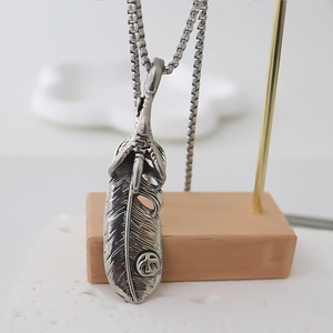 Macro di ciondolo a piuma d'argento con segno di pace su collana vintage a catena box