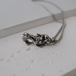 Detailed close-up of retro silver PiXiu pendant with intricate vintage textures on chain