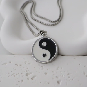 Collier avec pendentif Yin Yang Tai Chi style chinois et chaîne argentée sur fond blanc