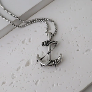 Close-up of vintage stainless steel anchor pendant with rope detail on box chain