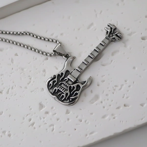 Gros plan détaillé d'un collier pendentif guitare vintage avec motifs flammes évidés