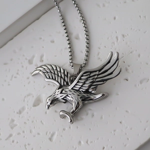 Détail macro du pendentif aigle en argent vieilli montrant les textures des plumes en relief