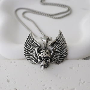 Detailed close-up of gothic skull pendant with wings on a steel box chain necklace
