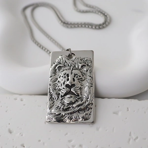Détail macro d'un pendentif rectangulaire tête de lion gaufré sur une chaîne en métal