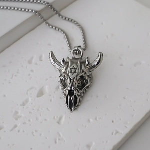Macro view of vintage silver bull skull pendant with hexagram detail on box chain