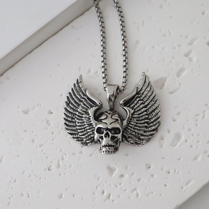 Macro view of vintage punk skull pendant with wings on a steel box chain