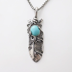 Vintage silver feather pendant necklace featuring a polished oval turquoise stone inlay