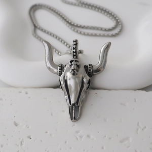 Gros plan détaillé d'un pendentif tête de taureau rétro avec textures punk argent